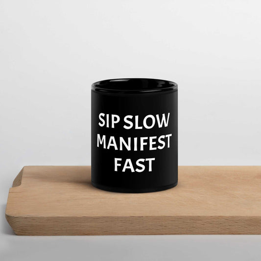 Black glossy mug with "Sip slow, manifest fast" affirmation and high-gloss finish