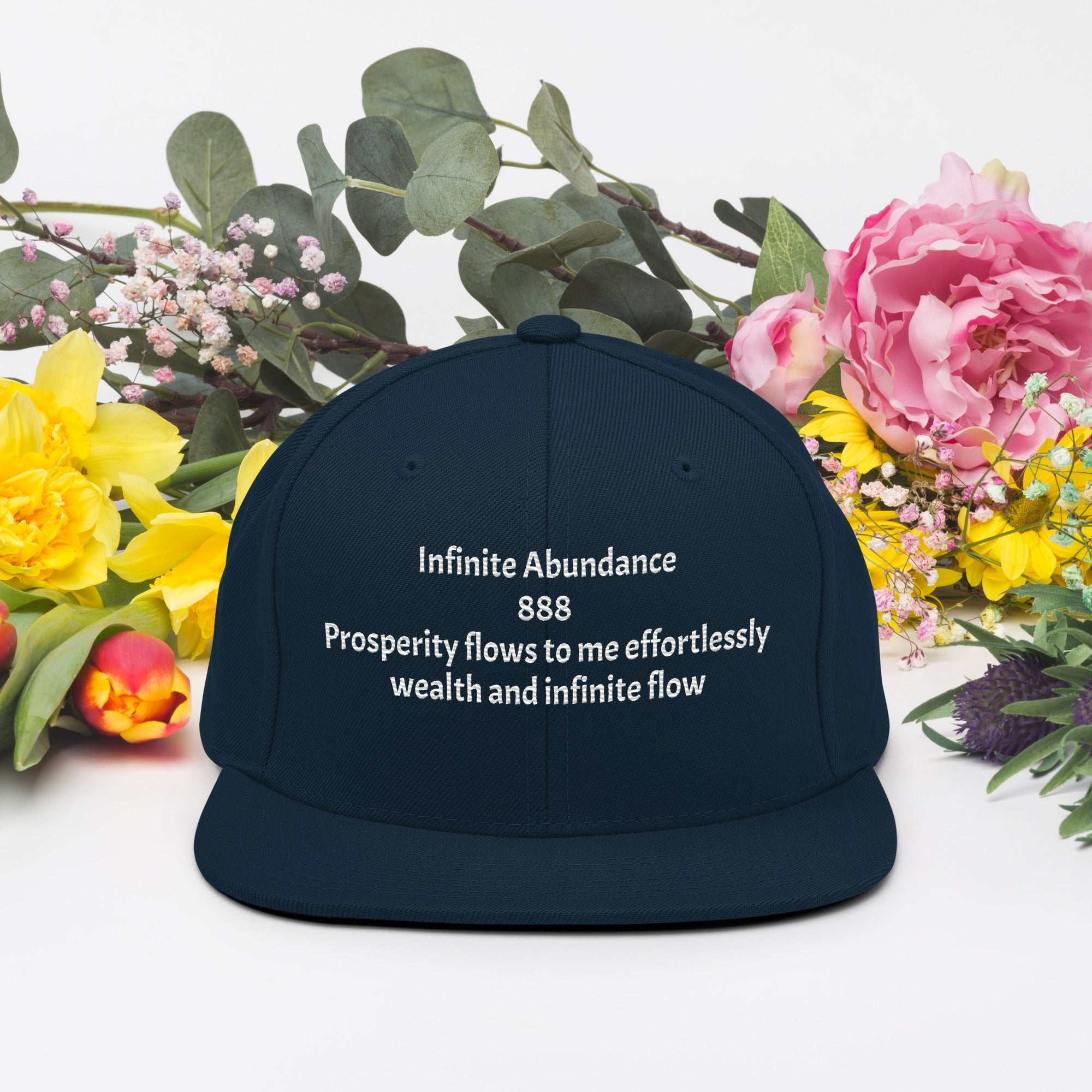 Black snapback hat with embroidered white spiritual affirmation text and floral background